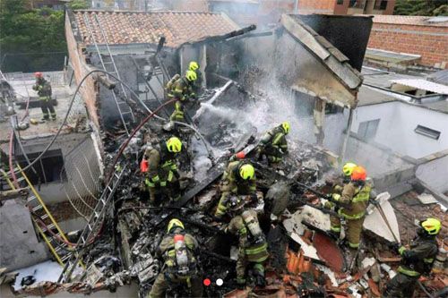 Gaszenie pożaru po katastrofie samolotu Piper PA-31, który spadł na domy w Medllin w Kolumbii / Zdjęcie: baaa-acro