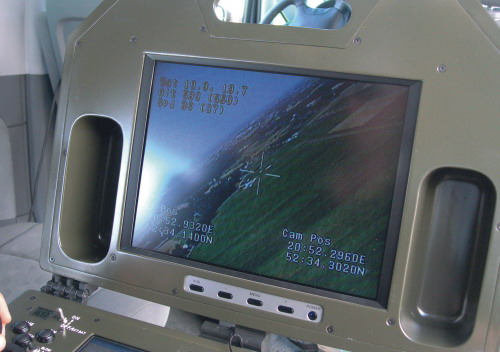 Na zbliżeniu widać, iż na monitorze z obrazem z kamery podawane są także dane o koordynatach aparatu i punktu obserwacji oraz prędkości i wysokości lotu samolotu oraz stanie baterii. 