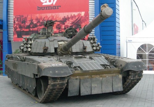 PT-91Ex (już nie PT-91E jak był określany w 2006 i nie PT-91M, bo tak sobie zażyczył klient) - bardzo wyczekiwany eksponat przyjechał do Kielc dopiero w nocy z pierwszego na drugi dzień Salonu. Nie był więc pokazany oficjalnym gościom podczas otwarcia. Ciekawe podejście. Pojazd nie mógł być oficjalnie określany mianem Malaja, mimo iż zachowano praktycznie nie zmienione znaki rejestracyjne, używane przez 2 prototyp pojazdu podczas prób w Malezji. Jako oferta m.in. dla polskiego odbiorcy pojazd powinien być wyposażony w sprzęt rodem ze spółek Bumaru i z nimi współpracujących: w polskie radiostacje, polski system zarządzania polem walki i intercom, w polskie karabiny maszynowe itd. Pokazywano go jednak w oryginalnej konfiguracji malajskiej, co też jest kuriozalne samo w sobie / Zdjęcie: Grzegorz Hołdanowicz