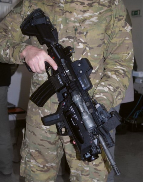 Karabinek automatyczny HK416D145RS z podwieszanym granatnikiem AG-HK416 (ELM), celownikiem holograficznym EOTech HWS.553 (SU-231/PEQ), DBAL-A<sup>2</sup> (AN/PEQ-15A) i latarką Surefire. Warto zwrócić uwagę na dwuwymiarowy kod kreskowy (matrycowy), na celowniku i wskaźniku, jakim oznaczane są od poprzedniego roku wszystkie amerykańskie urządzenia wojskowe i broń (mające numery NSN, czyli istniejące w systemie logistycznym amerykańskich Sił Zbrojnych)