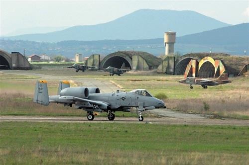 Amerykański A-10 Thunderbolt II na drodze kołowania na lotnisku w Bezmer. Na drugim planie, przed schronohangarami, trzy wycofane ze służby Su-25 / Zdjęcie: USAF