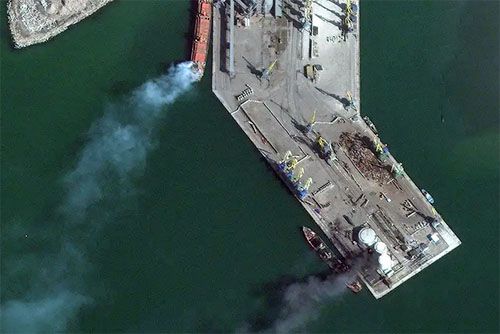 Nabrzeże portu w Berdiańsku. Na dole widoczny ciemny dym unoszący się nad desantowcem Orsk, a u góry jaśniejszy na statkiem cywilnym. Dymy unoszą się też nad zbiornikami (elewatorami) na nabrzeżu / Zdjęcie: Maxar Technologies