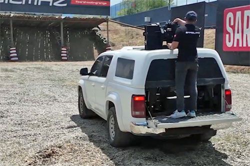 Po wysunięciu z wnętrza samochodu wieżyczki z karabinem maszynowym operator przygotowuje ją do strzelania / Zdjęcie: kadr z filmu Best Defense