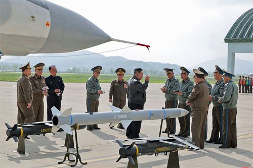 Prezentacja nowego kpr powietrze-powietrze średniego zasięgu Kim Dzong Unowi. Obok pocisku nowe bomby precyzyjne dalekiego zasięgu, które także były testowane podczas ćwiczeń / Zdjęcia: KCNA
