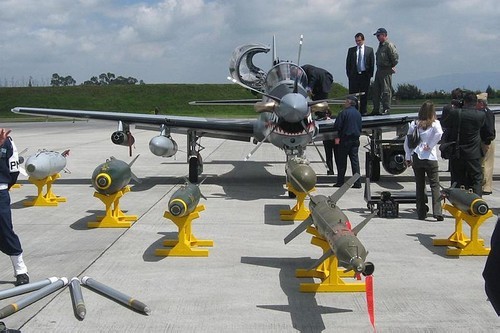 Konkurencyjny, brazylijski Super Tucano. Jego największą zaletą jest sprawdzona konstrukcja i fakt zintegrowania wielu typów uzbrojenia, od karabinów i działek kalibru 12,7 oraz 20 mm, przez klasyczne bomby i npr kalibru 70 mm, po bomby kierowane, zapalające, kasetowe oraz pociski powietrze-powierzchnia i powietrzne-powietrze. Specjaliści wskazują również na fakt, że ma nieco większe wymiary niż Texan II oraz podwozie lepiej przystosowane do operowania z przygodnych lądowisk / Zdjęcie: Dafranca