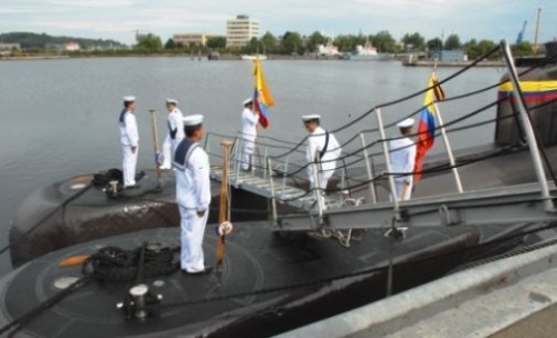 Kolumbijscy marynarze w trakcie symbolicznego stawiania flagi państwowej na kadłubie przejętych okrętów