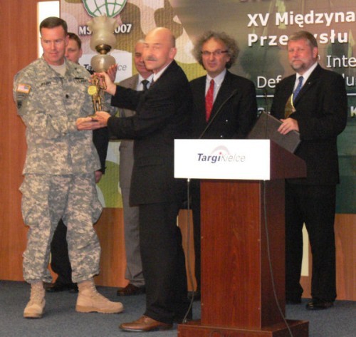 Wojciech Łuczak wręcza nagrodę dziennikarzy, ufundowaną przez RAPORT-wto, za najatrakcyjniejsze stoisko MSPO dla przedstawiciela U.S. Army, Program Executive Office Soldier
