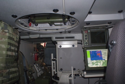 Przednia część przedziału desantu, po prawej stanowisko dowódcy wozu z pulpitem sterowniczym zsmu Kobuz oraz terminalem komputerowym, po lewej miejsce dla (opcjonalnego) medyka, po lewej w głębi widoczny przedział kierowania
